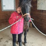 Photo de Angèle, jeune fille de 12 ans atteinte du syndrome CTNNB1. Elle est accompagnée d'un cheval.